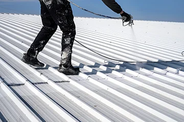 A worker coating the roof with foam
