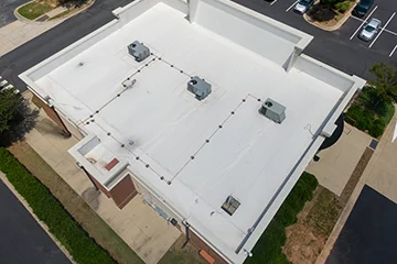 A worker coating roof with silicon